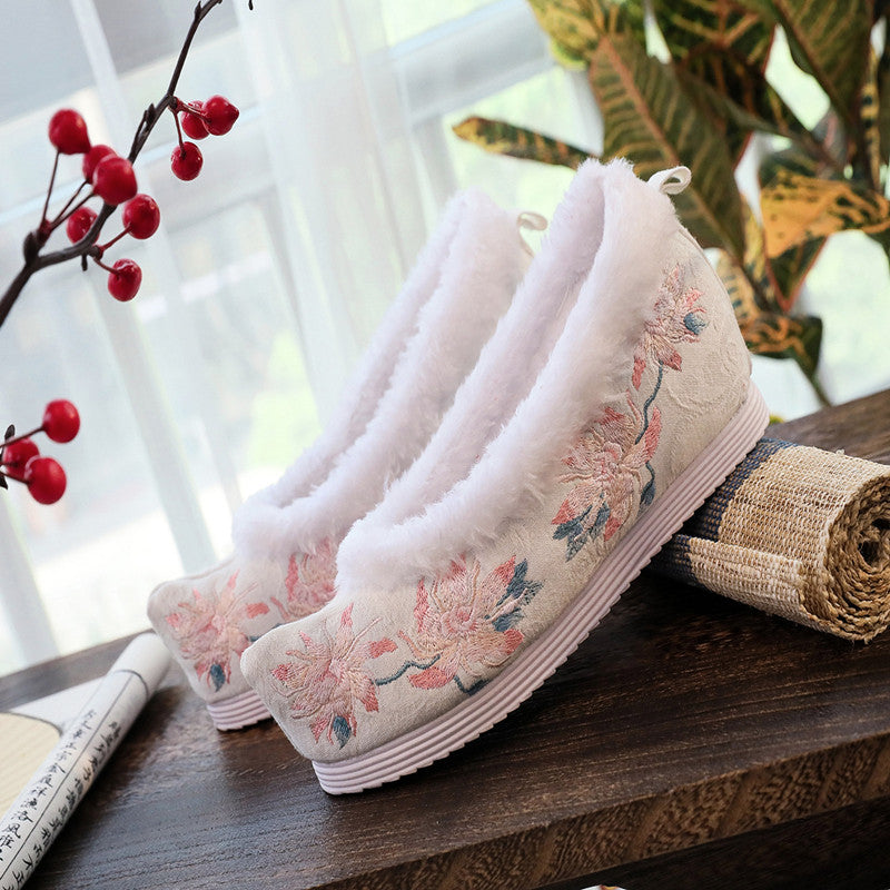 Scarpe femminili antiche in cotone ricamato Valstrend, dettagli di cuciture e design tradizionale su fondo chiaro.