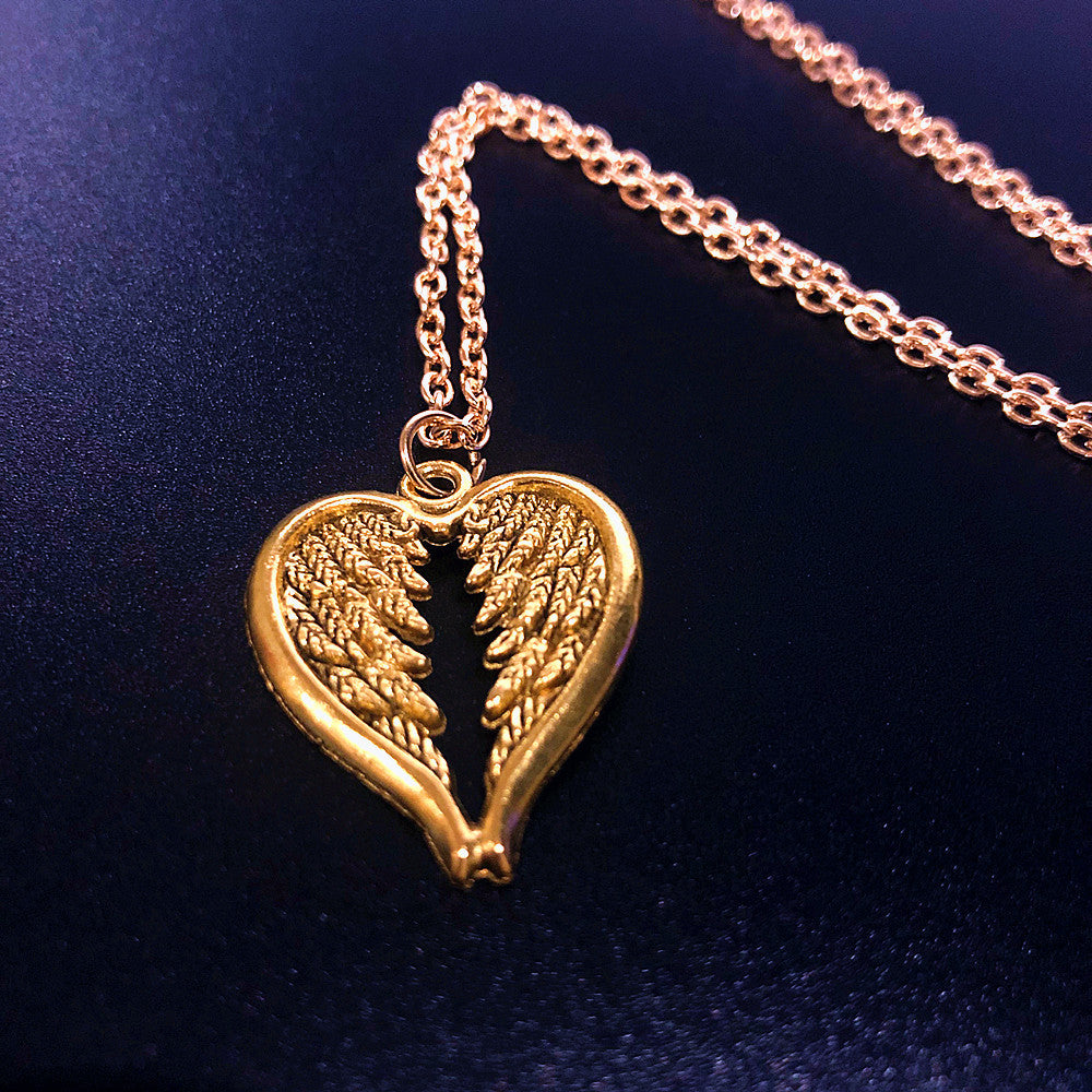 Collana vintage con pendente a forma di ali e cuore, stile popolare, brand Valstrend, dettagli artistici e design elegante.
