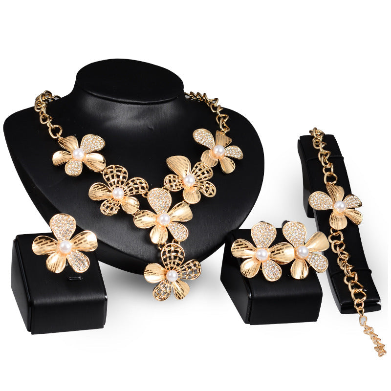 Set di gioielli in lega dorata Valstrend con quattro pezzi, include collana, orecchini, anello e bracciale eleganti.