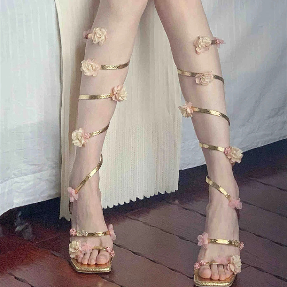 Sandali romani con tacco sottile e fiori, scarpe Valstrend shop in pelle con dettagli floreali e design elegante.