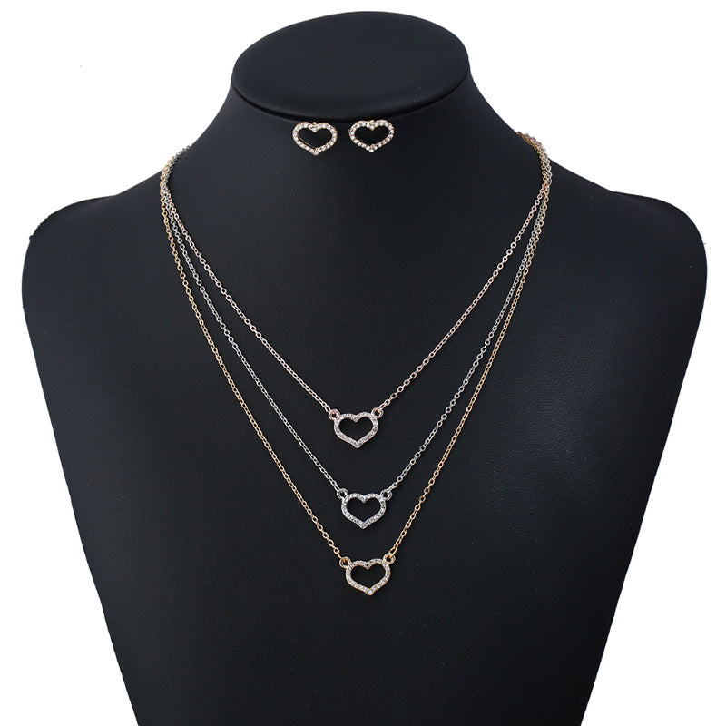 Set di orecchini e collana Valstrend con pendente a forma di croce e dettagli in stile love e diamanti.