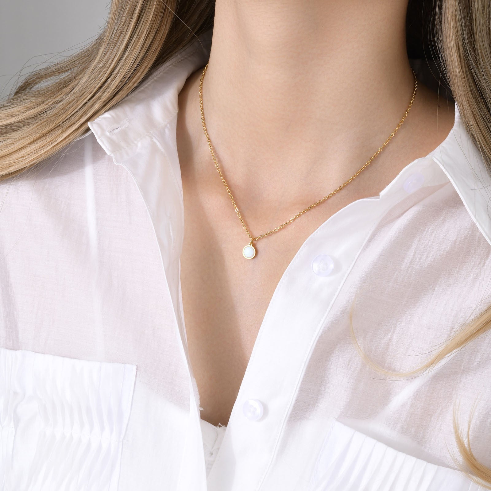 Collana donna con pendente rotondo in opale, stile fashion, di Valstrend, mostra il pendente lucido e riflettente in primo piano.