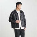 Cappotto in pelle PU da uomo di moda, stile top, con colletto e chiusura frontale, in nero, indossato da uomo.