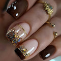 Unghie finte a squoval con finitura lucida marrone e oro con strisce e glitter, set da 24 pezzi per manicure femminile.