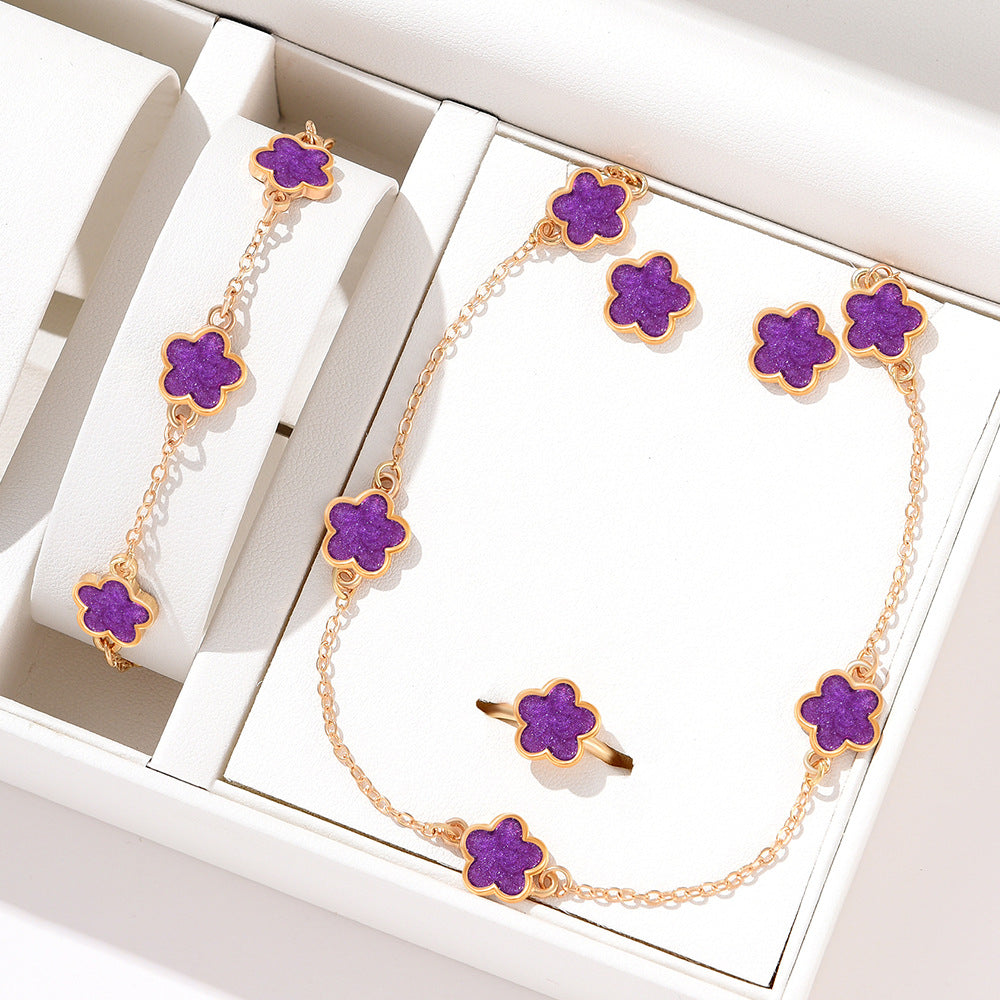 Completo di gioielli Lucky Flower da Valstrend, con collana e orecchini con fiori e dettagli eleganti in metallo dorato.