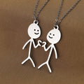 Collana con pendente a forma di simpatico stickman cartoon in acciaio inossidabile, stile divertente e moderno.
