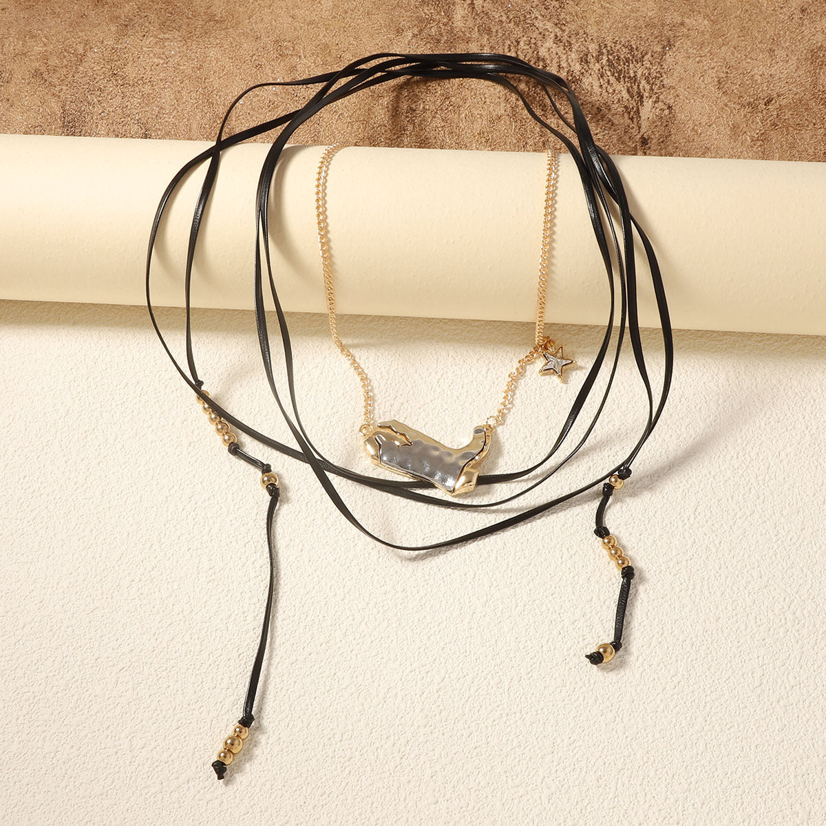 Collana lunga multi-strato in metallo alla moda, stile trendy, con dettagli eleganti e moderni, indossata su sfondo neutro.