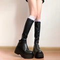 Stivali slim aderenti da donna Valstrend, scarpe alte elastiche e modellanti, visibili in primo piano sulla donna.