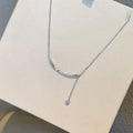 Collana elegante in argento sterling con nappine e diamanti, design raffinato e sofisticato, indossata con stile e classe.