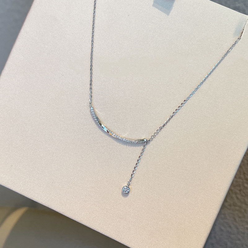Collana elegante in argento sterling con nappine e diamanti, design raffinato e sofisticato, indossata con stile e classe.