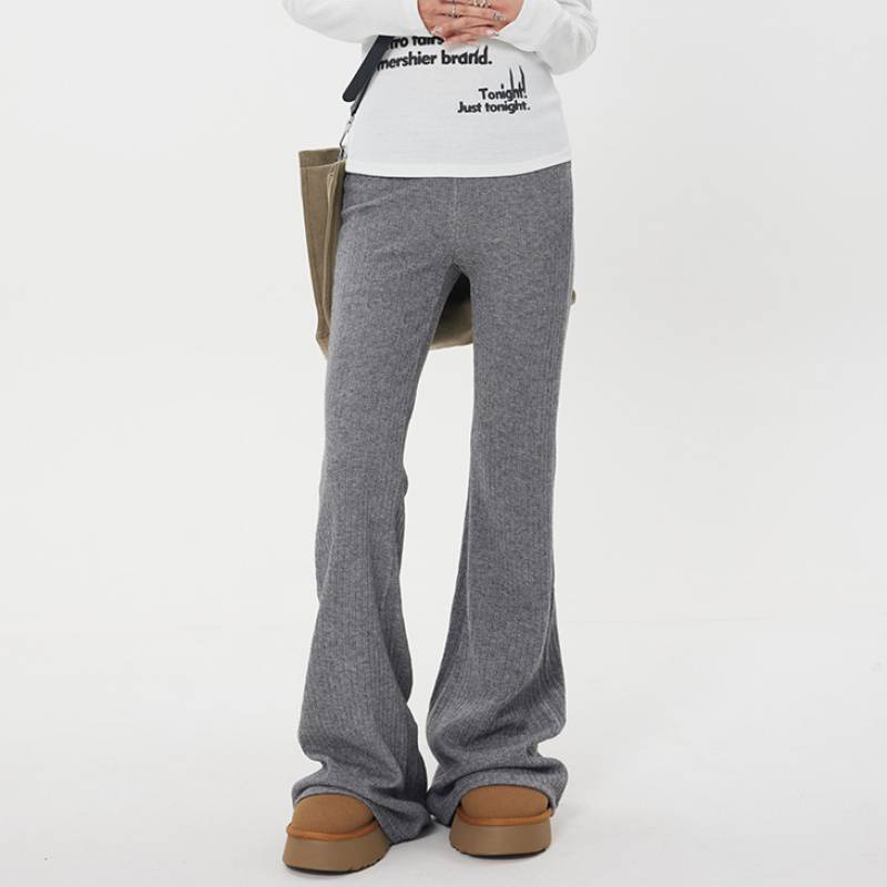 Pantaloni casual a vita alta in maglia per donna, in tessuto morbido e comodo, indossati con una camicia bianca.
