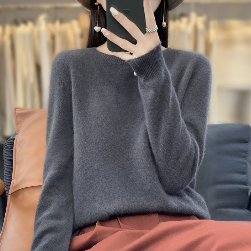 Maglione da donna in cashmere lavorato a maglia morbido e largo, colore neutro, indossato con maniche lunghe e scollo rotondo.