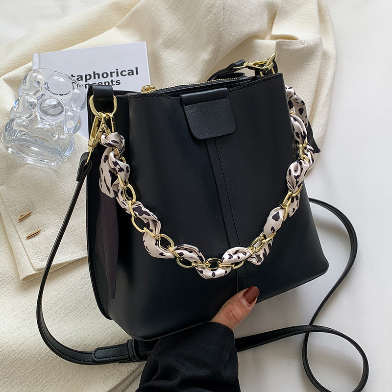 Borsa a tracolla donna Valstrend con design a secchiello, catena e tessuto texturizzato, stile moda e pratico.