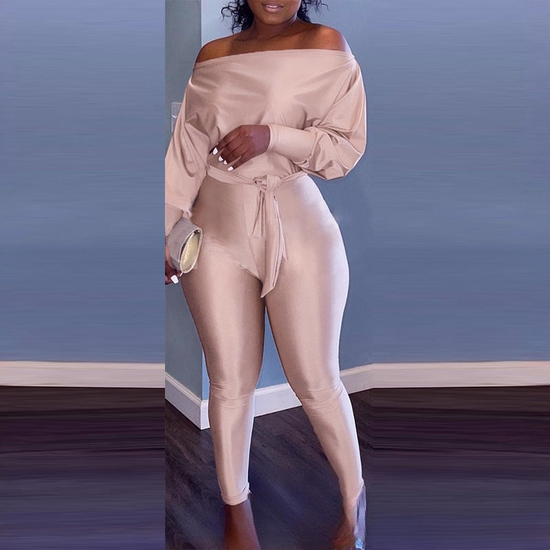 Completo jumpsuit donna Valstrend con scollatura a spalle scoperte, maniche lunghe e vita stretta, in tessuto champagne elegante.