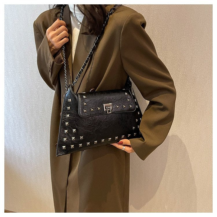 Borsa a tracolla Rivet Bag Envelope Chain di Valstrend con dettagli a borchie e tracolla a catena in pelle sintetica.