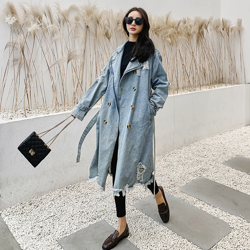 Cappotto trench in denim retrò da donna di Valstrend, stile vintage con cintura e dettagli classici in tessuto blu denim.