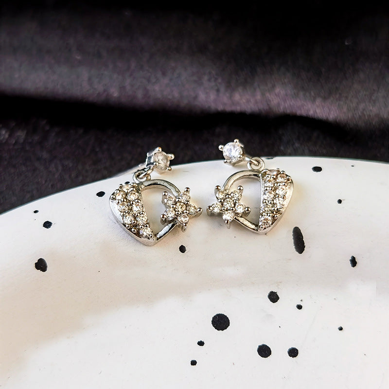 Orecchini a perno in zirconio con dettaglio a fiore traforato e motivo di cuore, donna, stile elegante e femminile.