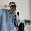 Camicia jeans da uomo a maniche corte Valstrend con stile baggy e taglio casual, dettaglio tessuto denim blu.