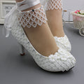 Scarpe con tacco alto bianche Valstrend per sposa, modello con allacciatura, taglie forti, su sfondo neutro.