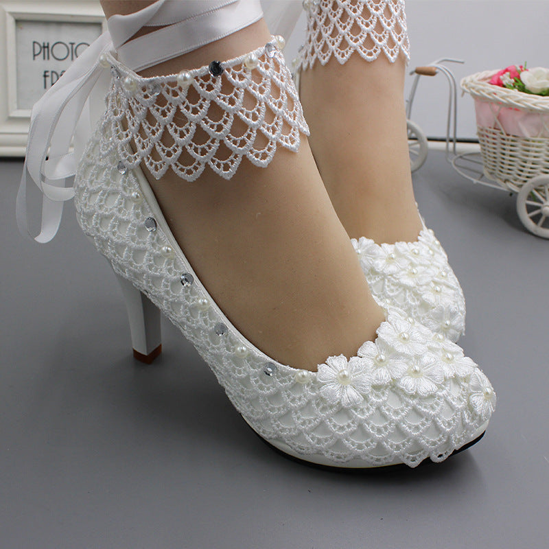 Scarpe con tacco alto bianche Valstrend per sposa, modello con allacciatura, taglie forti, su sfondo neutro.