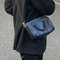 Borsa Boston in denim patchwork retrò e pelle, stile vintage, con dettagli colorati e tracolla regolabile.