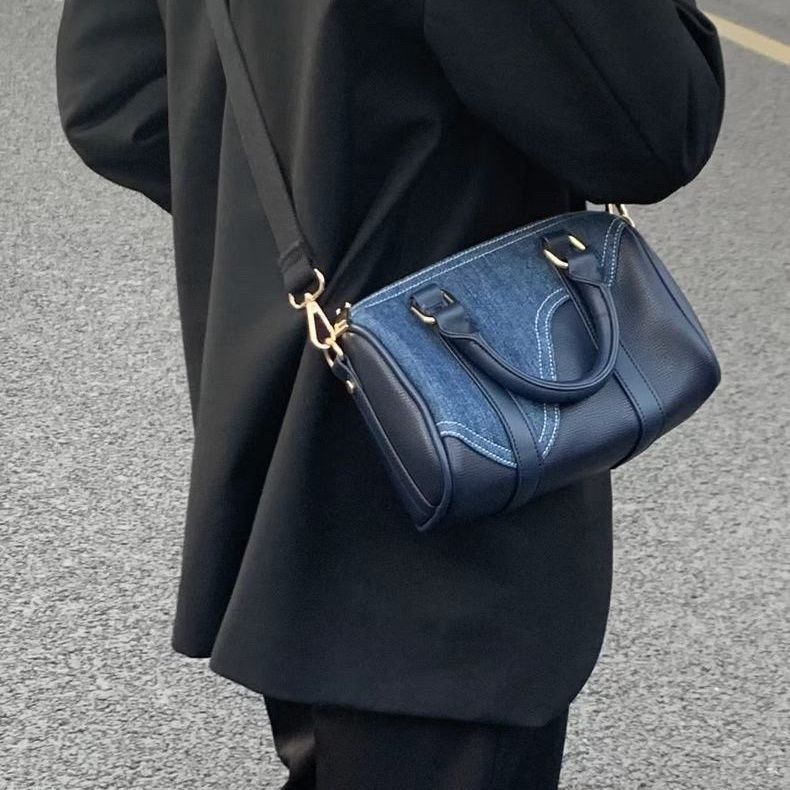Borsa Boston in denim patchwork retrò e pelle, stile vintage, con dettagli colorati e tracolla regolabile.