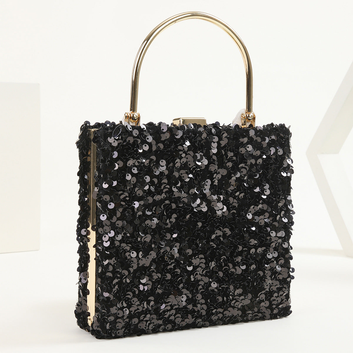 Mano di donna che tiene una pochette da sera colorata con paillettes, borsa da donna Valstrend shop con design brillante e vivace.