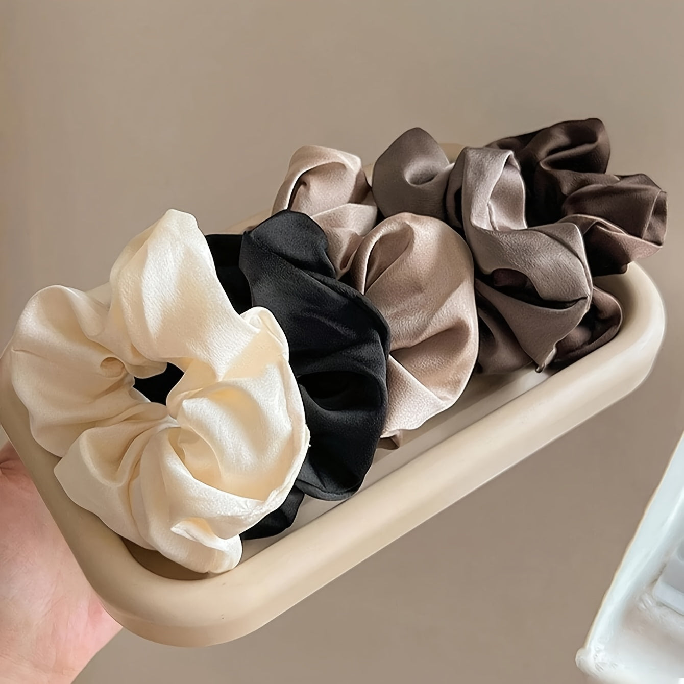 Set di 5 elastici per capelli Valstrend in nero, bianco e marrone, eleganti e versatili per tutte le età, visibili in immagine.