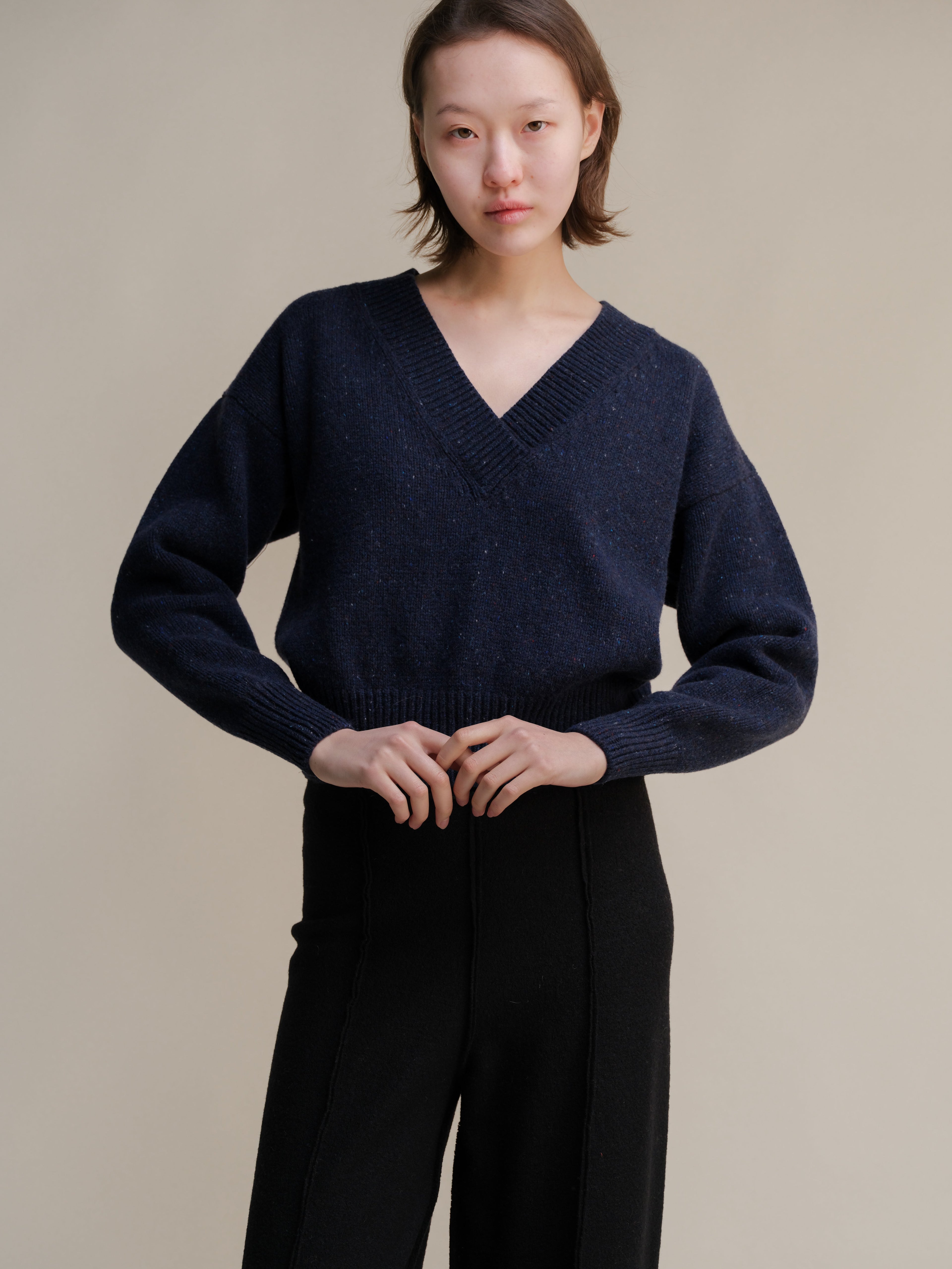 Maglione crop in tweed color caramello di Lèmme, con doppio scollo a V e stile knitwear.