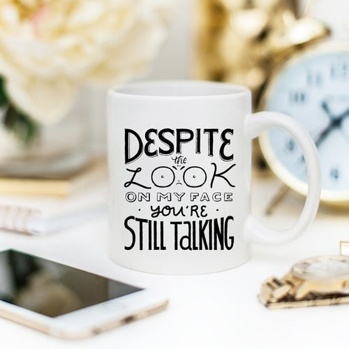 Tazza nera Sajishop con scritta "Despite The Look On My Face, You're Still Talking" in ceramica da 11 oz.