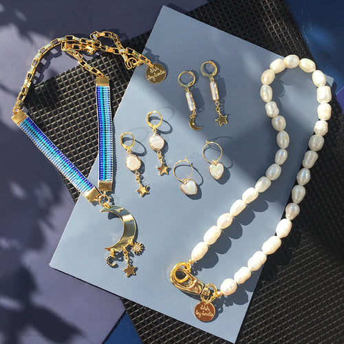 Orecchini a mezzaluna in cristallo con dettagli scintillanti, firma Sajishop, eleganti accessori moda.